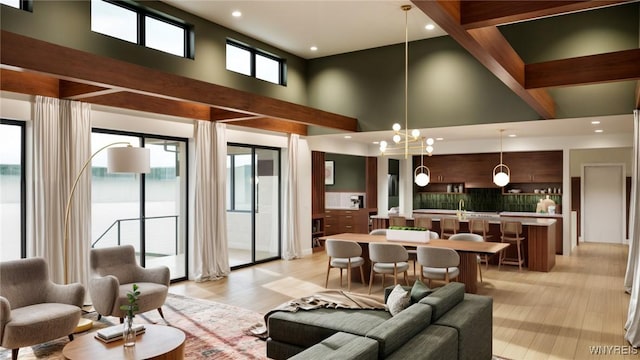living area with a towering ceiling, recessed lighting, and light wood-type flooring