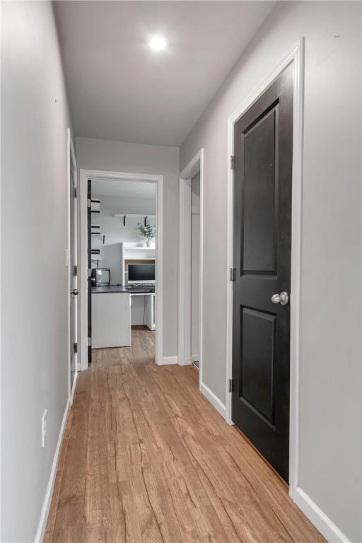 hallway with wood finished floors and baseboards