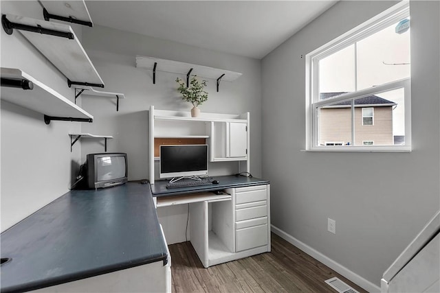 unfurnished office featuring wood finished floors and baseboards