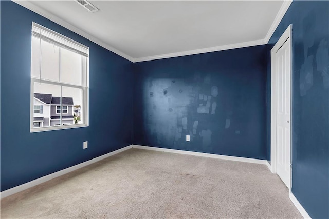 carpeted empty room featuring ornamental molding and baseboards
