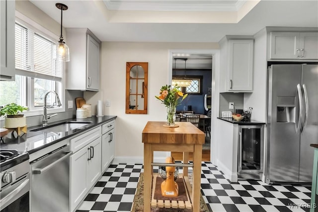 kitchen featuring stainless steel appliances, dark floors, a sink, wine cooler, and crown molding
