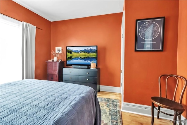 bedroom with wood finished floors and baseboards
