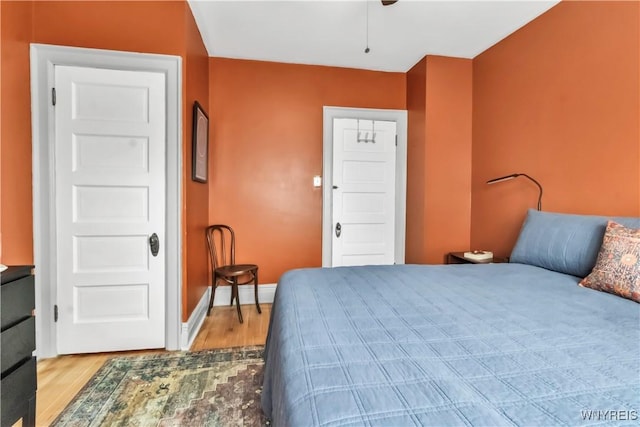 bedroom with wood finished floors and baseboards