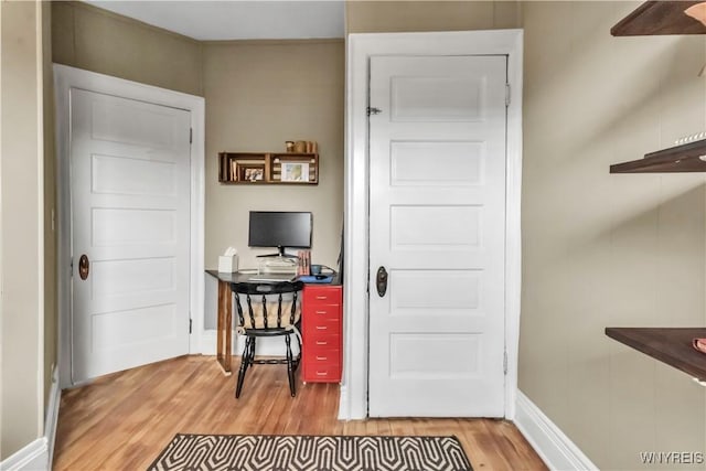 office area featuring light wood finished floors, baseboards, and ceiling fan