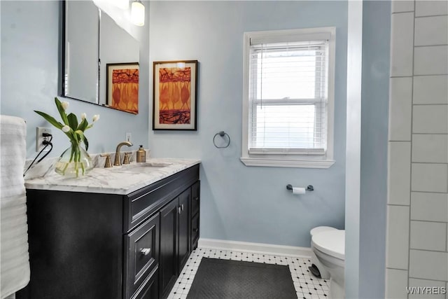 bathroom featuring toilet, baseboards, vanity, and tile patterned flooring