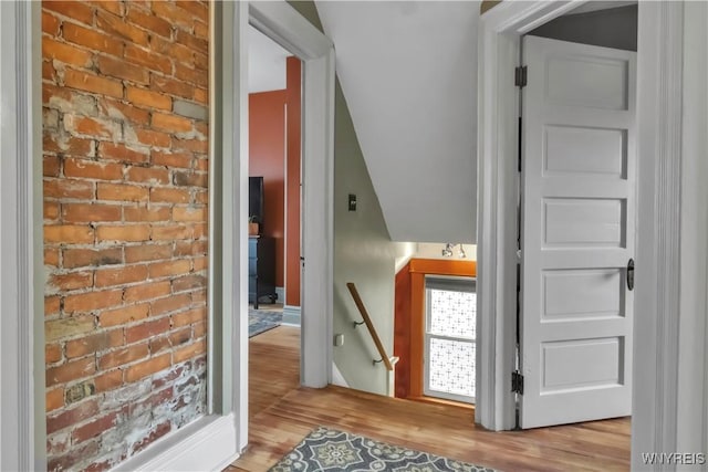 corridor featuring an upstairs landing and wood finished floors