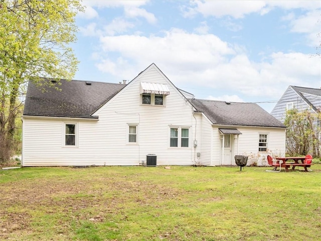 back of house with a yard and a shingled roof