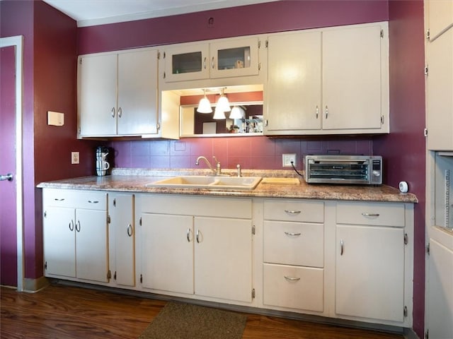kitchen featuring a sink, dark wood-style flooring, and white cabinets