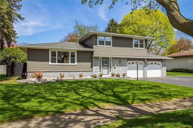split level home featuring asphalt driveway, an attached garage, and brick siding