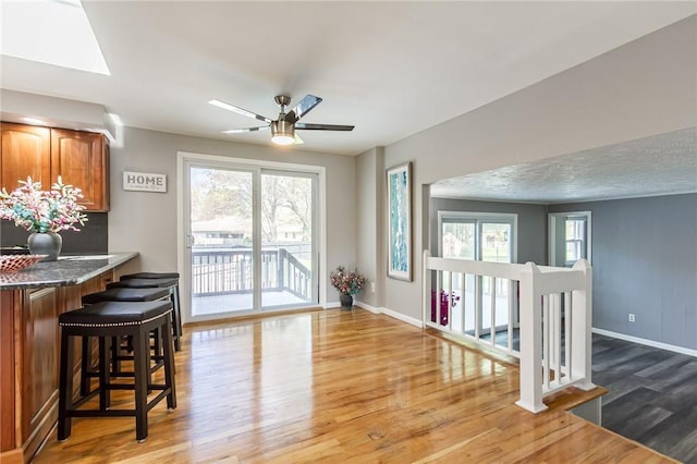 dining room featuring wood finished floors, baseboards, and ceiling fan
