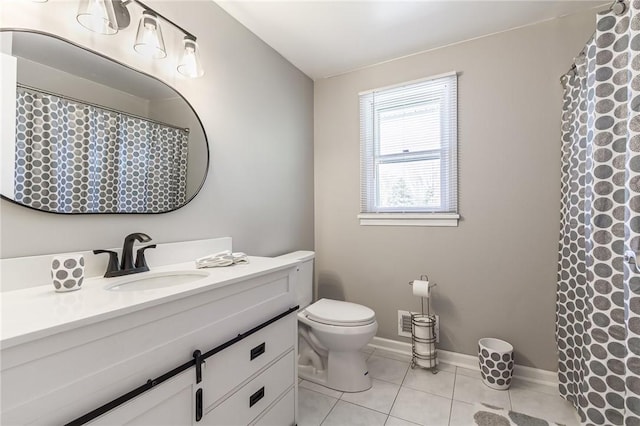 bathroom with tile patterned flooring, vanity, toilet, curtained shower, and baseboards