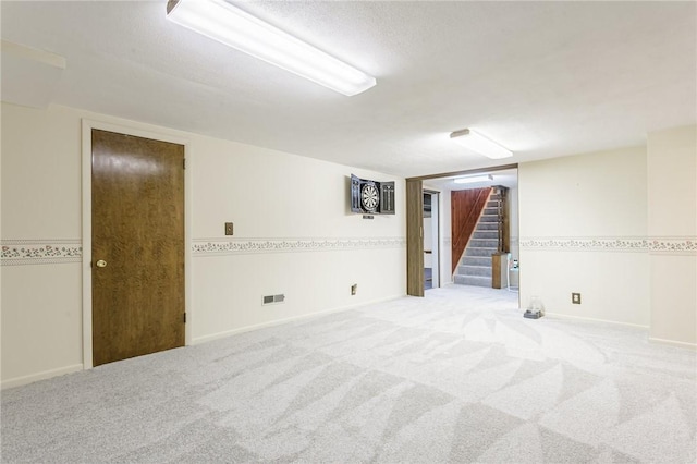 spare room featuring stairs, carpet, and baseboards