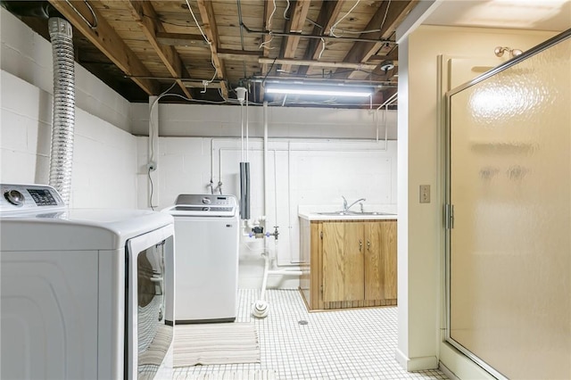 laundry room with washer and clothes dryer, concrete block wall, and light tile patterned floors