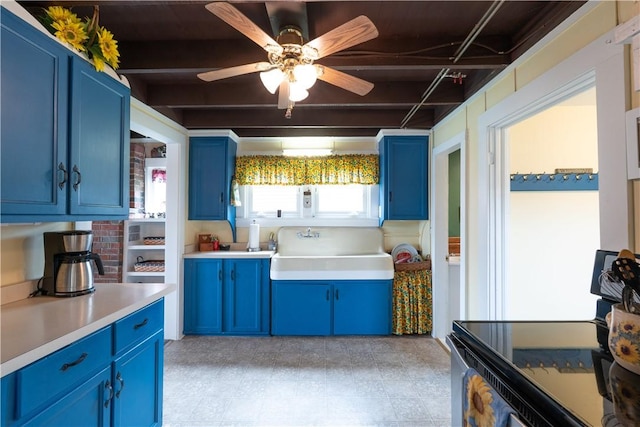 kitchen featuring blue cabinetry, range with electric cooktop, a sink, and light countertops