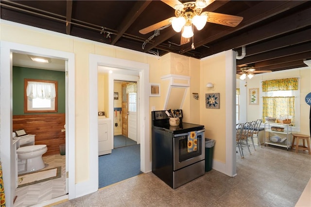 kitchen with electric range, a ceiling fan, and washer / dryer