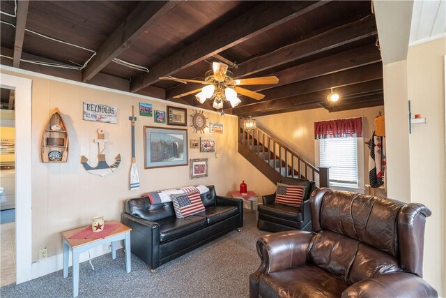 living room featuring carpet floors, wood ceiling, beam ceiling, stairs, and a ceiling fan