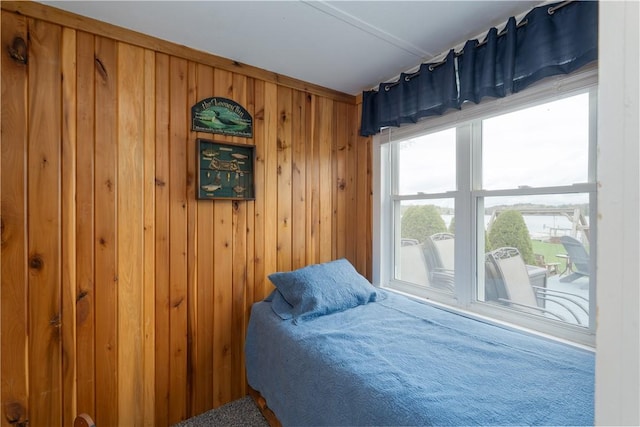 bedroom featuring wooden walls