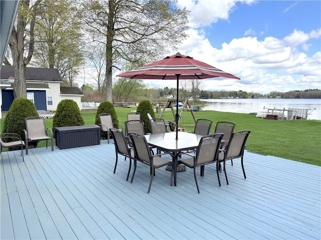 deck featuring a water view, outdoor dining area, and a lawn