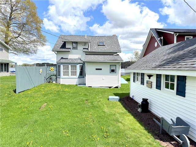 rear view of property featuring roof with shingles