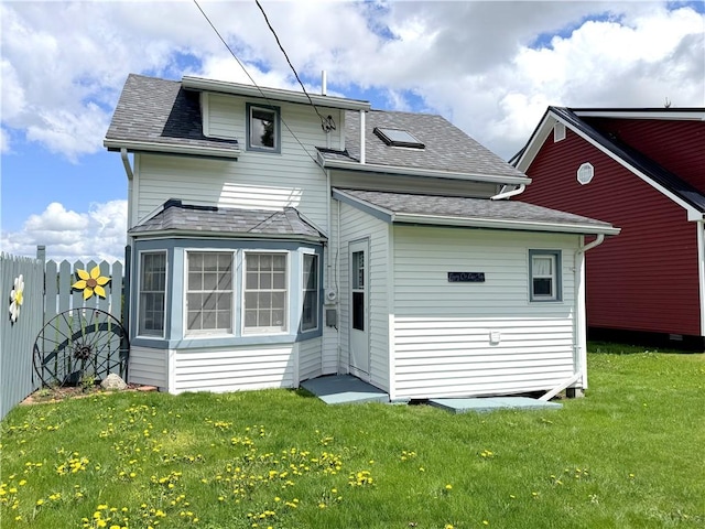 back of house with a shingled roof