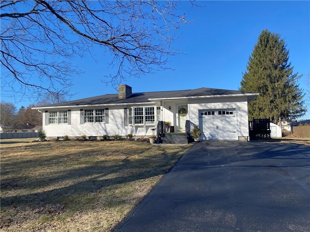 single story home featuring an attached garage, a chimney, and asphalt driveway