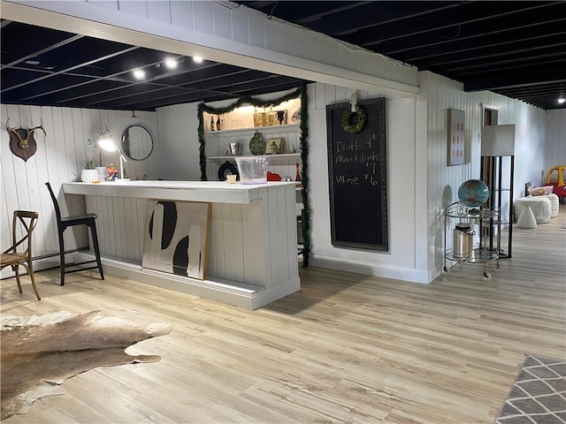 bar featuring wood finished floors and wooden walls