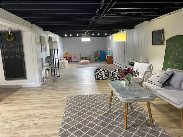 basement with wood finished floors and a baseboard heating unit