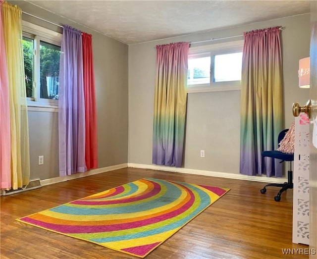 rec room with plenty of natural light, wood finished floors, and baseboards