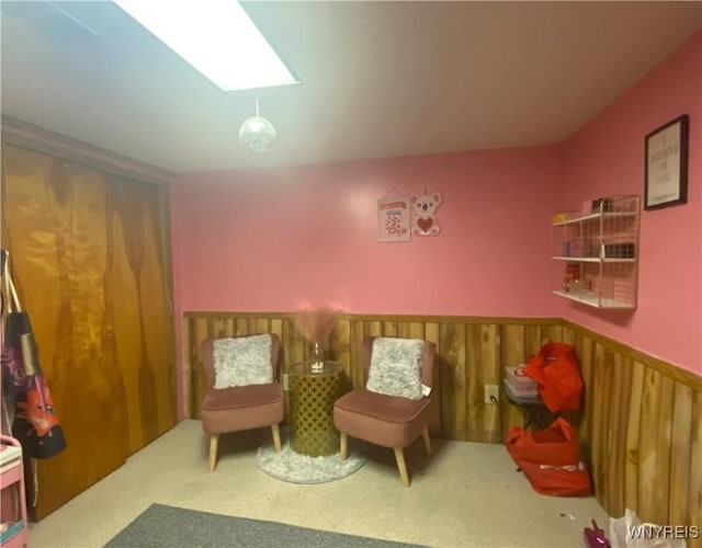 sitting room featuring carpet and wainscoting