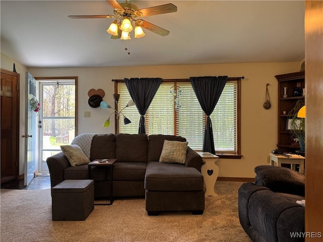 living room with carpet floors, a ceiling fan, and baseboards