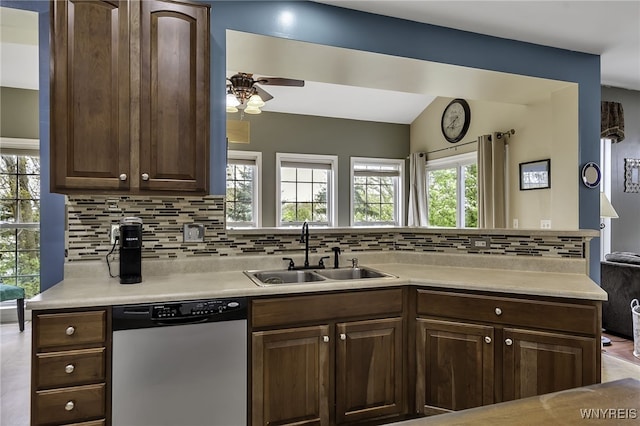 kitchen with stainless steel dishwasher, a sink, decorative backsplash, a ceiling fan, and a peninsula