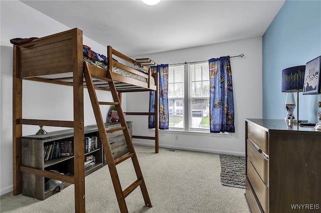 bedroom with light colored carpet and baseboards