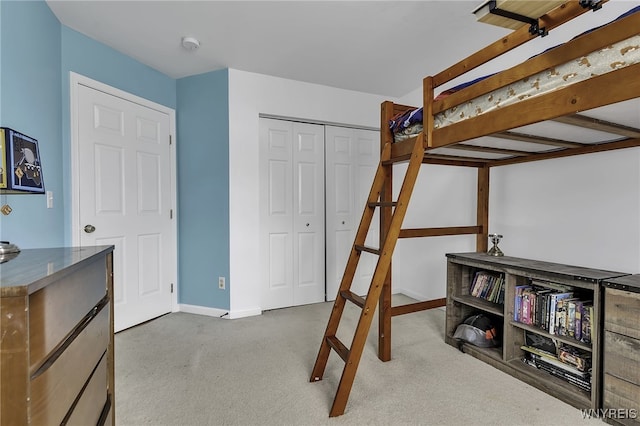 carpeted bedroom featuring baseboards and a closet