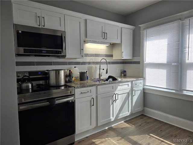 321 Hamilton Blvd, Tonawanda-Town, NY 14217 - kitchen featuring stainless steel microwave, range with electric cooktop, a sink, and tasteful backsplash