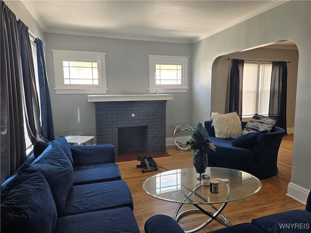 321 Hamilton Blvd, Tonawanda-Town, NY 14217 - living room featuring wood finished floors, arched walkways, a fireplace, crown molding, and baseboards