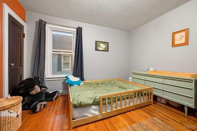 bedroom featuring wood finished floors and baseboards