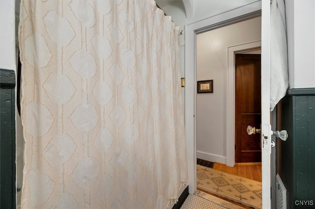 bathroom with wood finished floors and baseboards