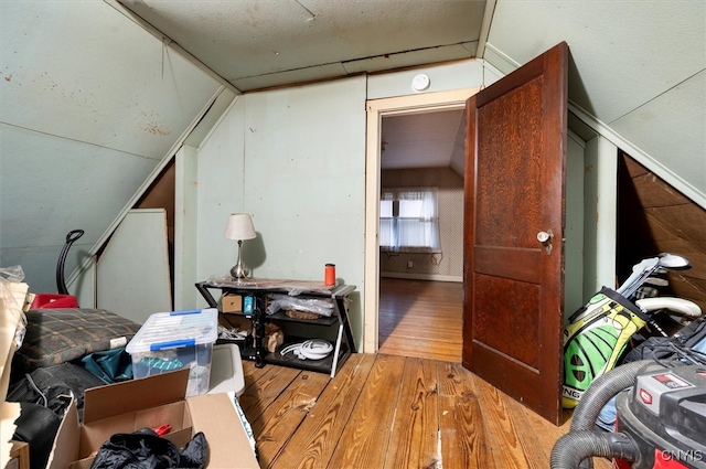 additional living space featuring wood-type flooring and vaulted ceiling