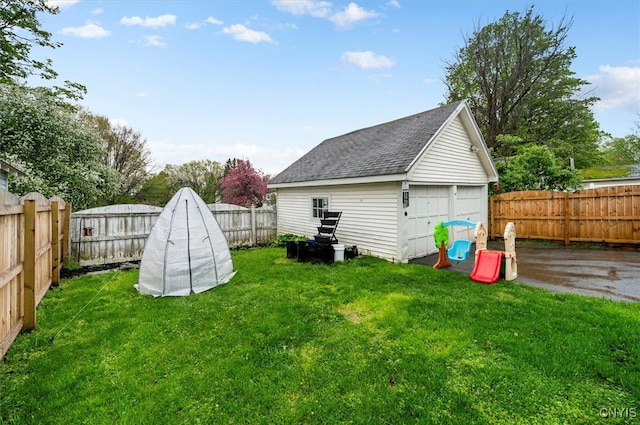 view of yard featuring a garage and an outbuilding