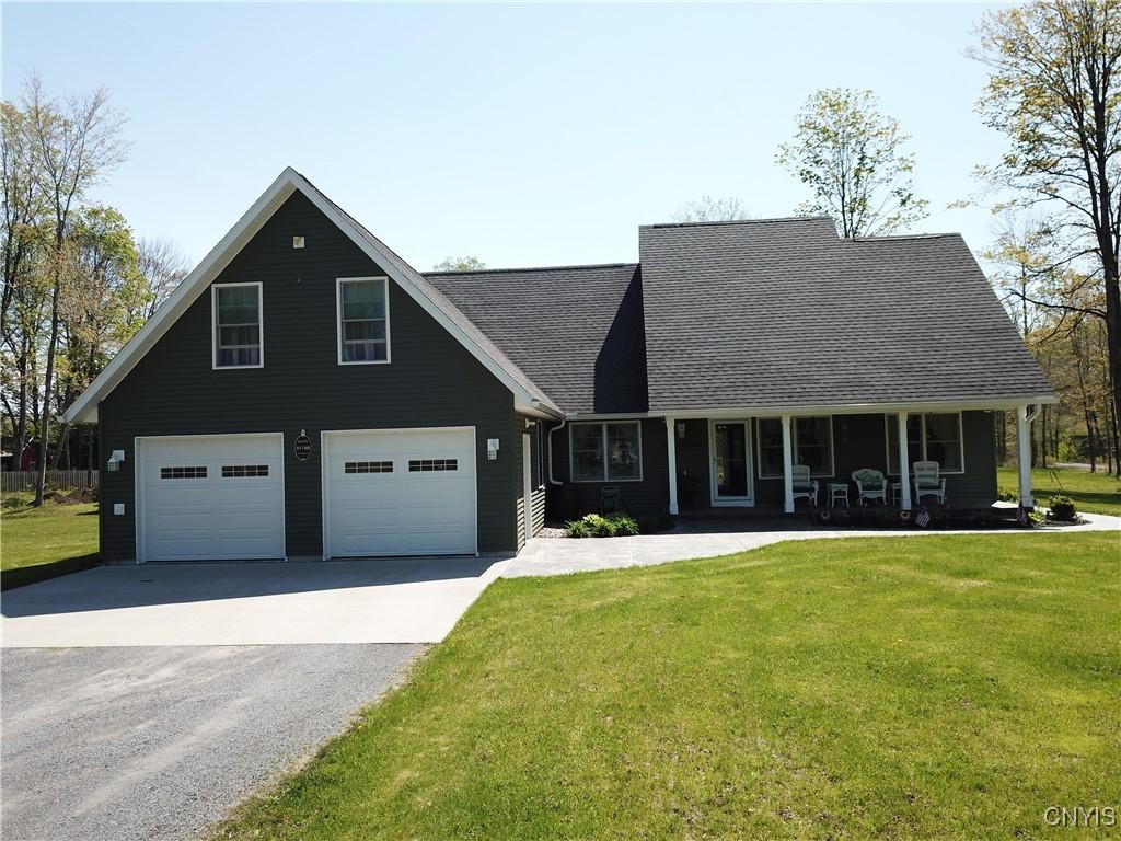view of front facade with a front yard, asphalt driveway, a garage, and roof with shingles