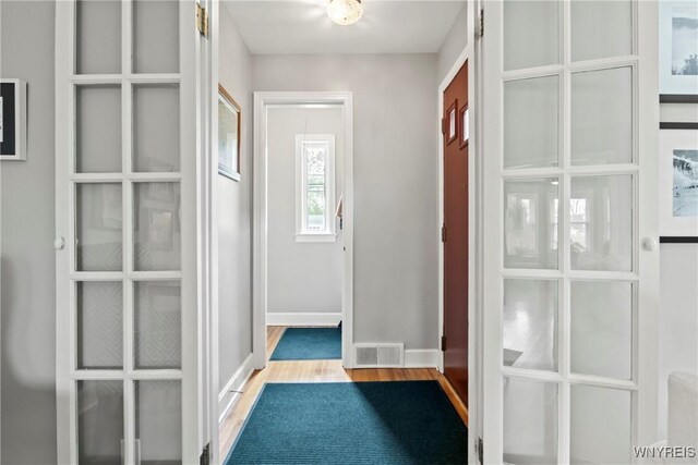 doorway to outside featuring wood finished floors and baseboards