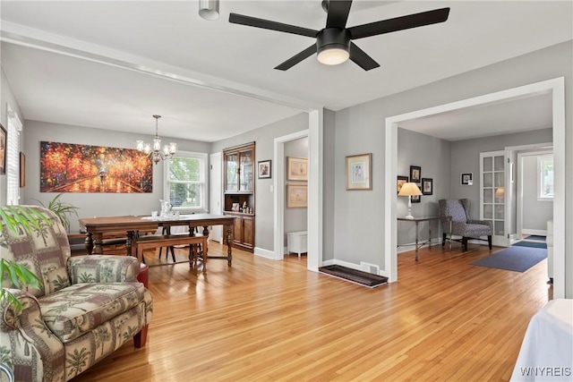 living room with light wood-style flooring, a chandelier, and plenty of natural light