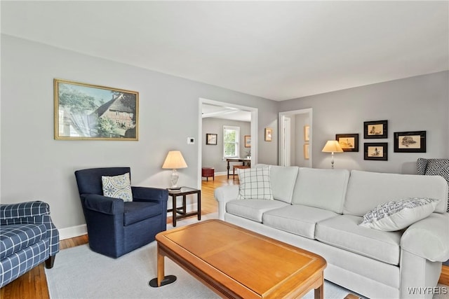 living area with baseboards and wood finished floors