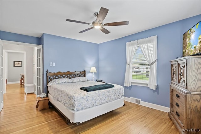 bedroom with light wood-style flooring, baseboards, and a ceiling fan