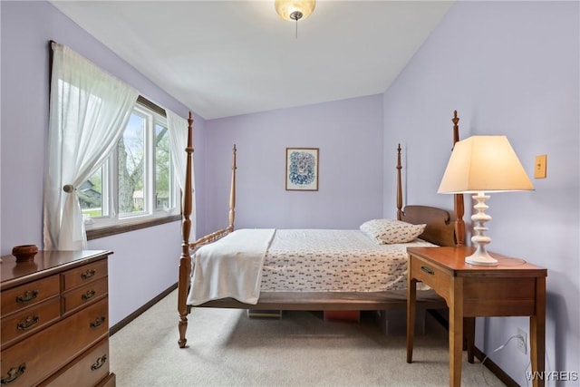 bedroom with light carpet and baseboards
