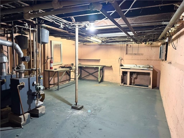 unfinished below grade area with a workshop area and a heating unit