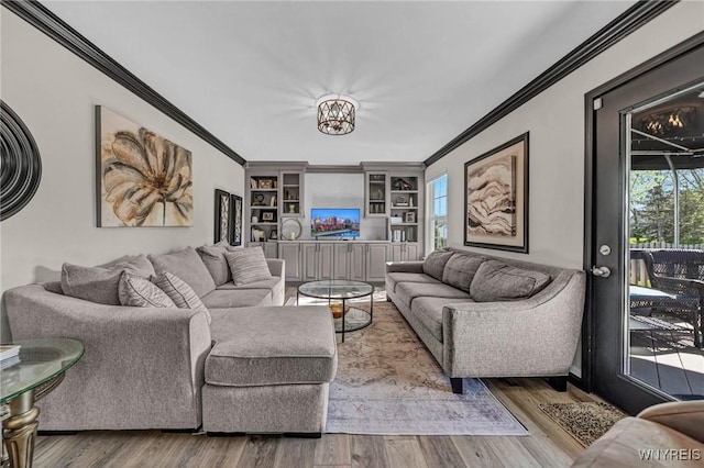 living area featuring ornamental molding, built in features, and wood finished floors