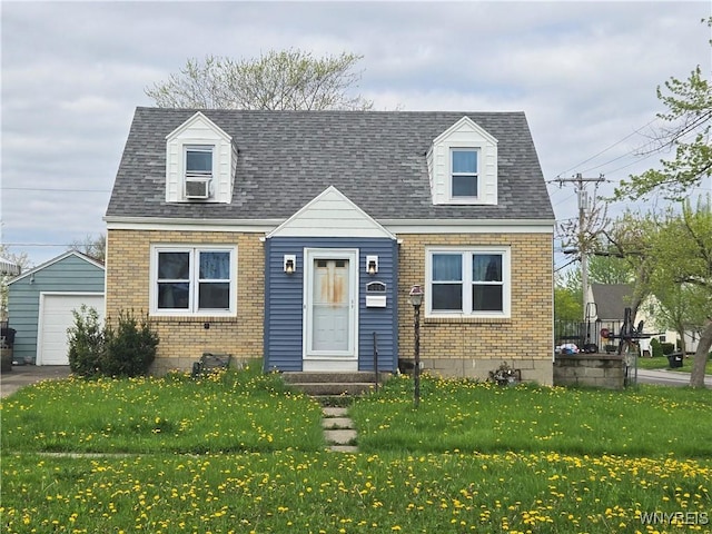cape cod home with brick siding, an outdoor structure, a front yard, a garage, and asphalt driveway