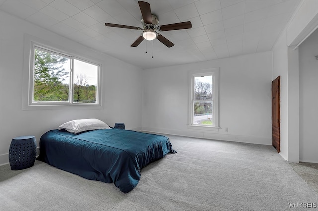 6043 Old Niagara Rd, Lockport Town, NY 14094 - carpeted bedroom with multiple windows, ceiling fan, and baseboards