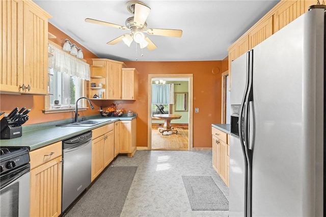 kitchen featuring appliances with stainless steel finishes, light brown cabinetry, and a sink